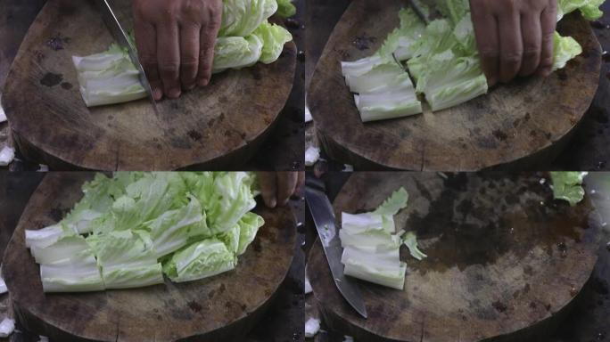 用小刀在木砧板上手工切割萝卜。