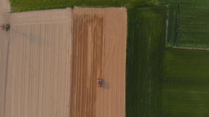 鸟瞰图: 拖拉机在耕地上工作，在山上的农田