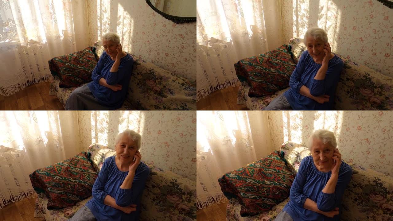 在家拿着手机的高级女性。祖母使用电话进行社交网络