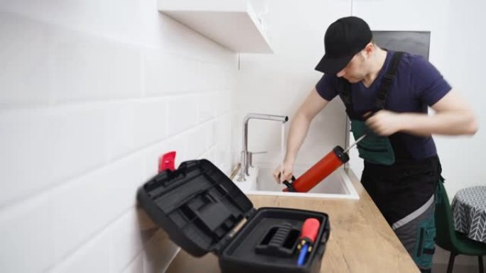 水管工用专业的力泵清洁剂疏通厨房水槽。
