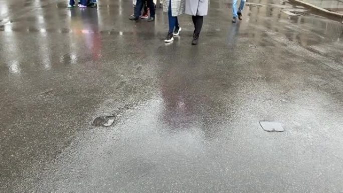 大城市的人行横道。人行横道的1英尺特写镜头。雨天。许多不同的鞋子。俄罗斯