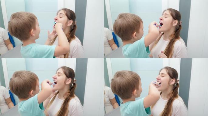蹒跚学步的小男孩在浴室为母亲刷牙和清洁牙齿