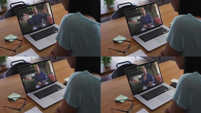 非裔美国妇女在家里的笔记本电脑上与男性办公室同事进行视频通话