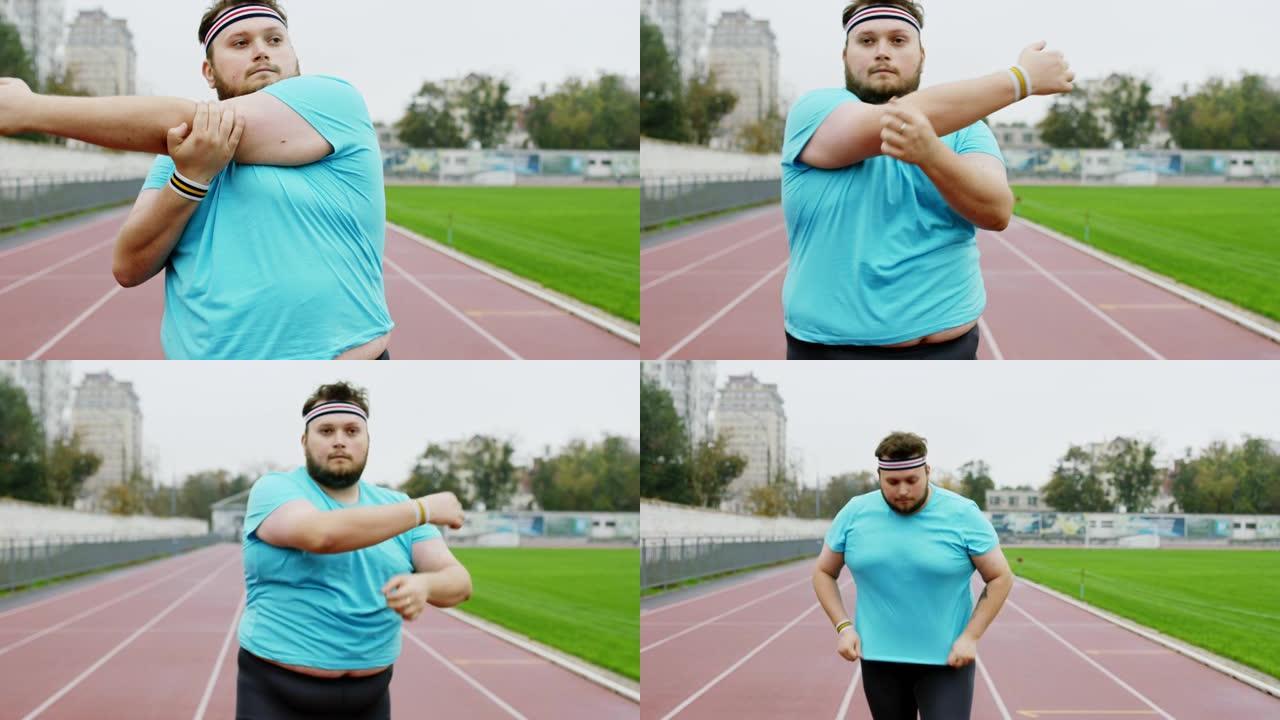 健康的生活方式概念肥胖的人在开始在体育场跑步之前伸展双手，他非常兴奋。在阿里·阿列克谢迷你上拍摄