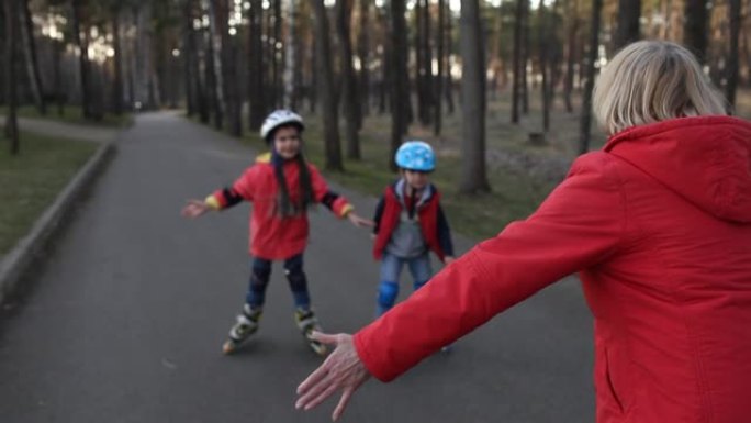 快乐的孩子和祖母一起在公园骑旱冰鞋，春季户外活动