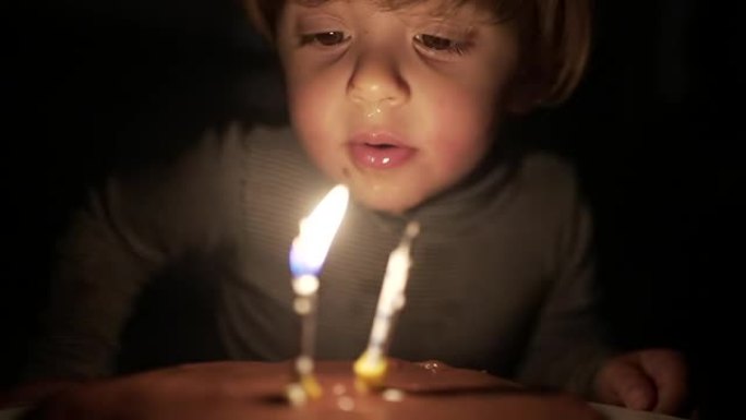 婴儿学步庆祝生日，孩子在慢动作中吹蛋糕蜡烛