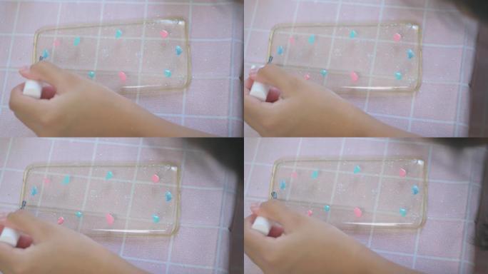 DIY女孩的手画旧的手机套与指甲油，可重复使用，生活方式的概念。