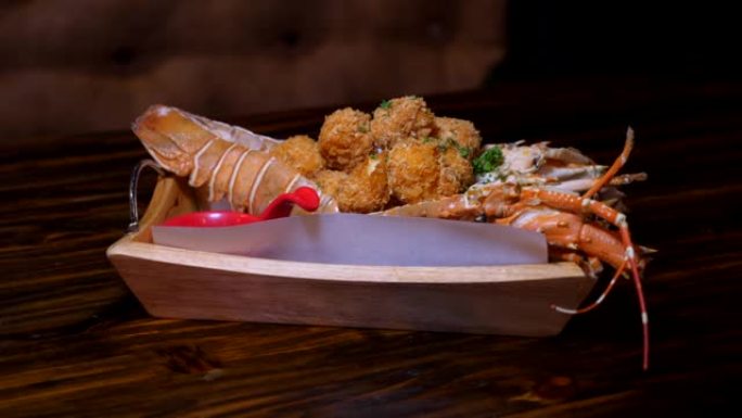 餐厅的木制桌子上提供煮熟的龙虾晚餐