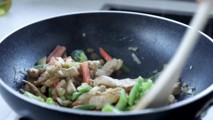 鸡肉在平底锅里炒，用木勺烹饪，亚洲食物