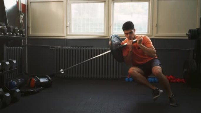运动男子在健身房做单腿地雷深蹲运动