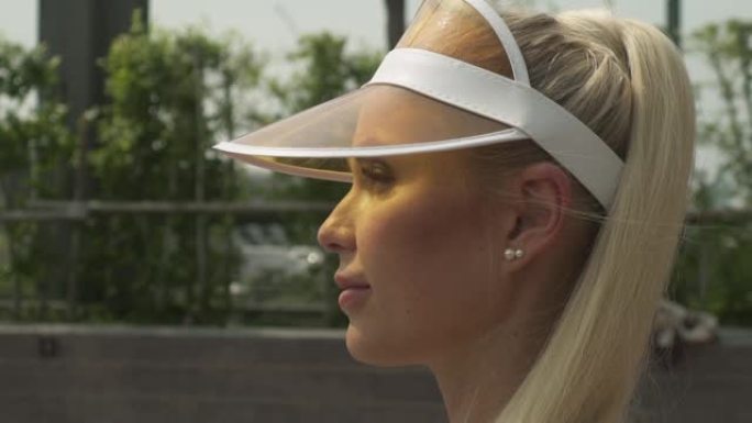 金发女网球运动员在阳光下的侧视图特写镜头
