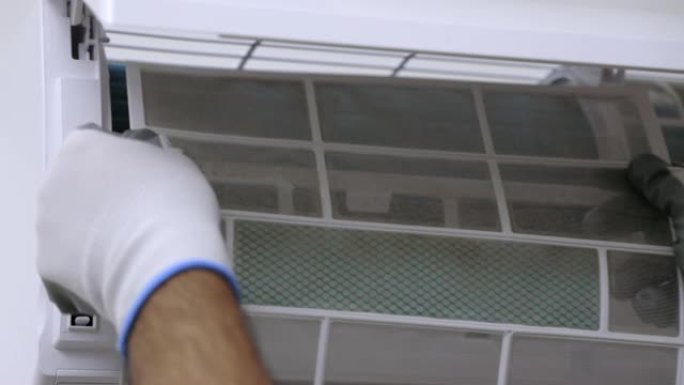 室内空调服务。空调清洁技术员他打开前盖并安装过滤器。