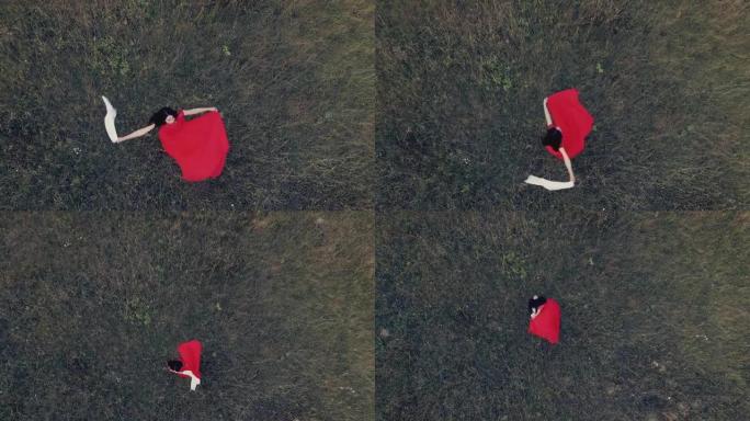 美丽的年轻女子旋转，然后穿着红色连衣裙躺在草地上