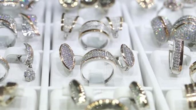 商店橱窗里的银首饰。结婚戒指和耳环。珠宝