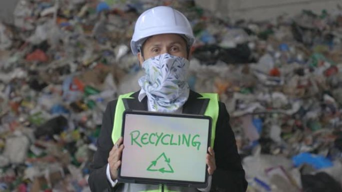 回收符号概念。在新型冠状病毒肺炎大流行回收中心工作的工程师，肖像。维修工程师在废物分离工厂工作时戴着