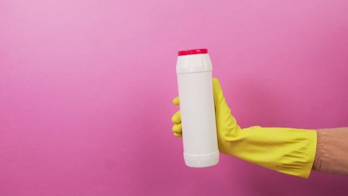 一只手戴着一只白色瓶子，上面有一个红色盖子，上面装有家用化学品。