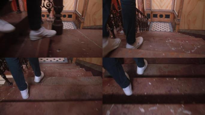 穿着白色运动鞋的腿走上房子里的石阶。