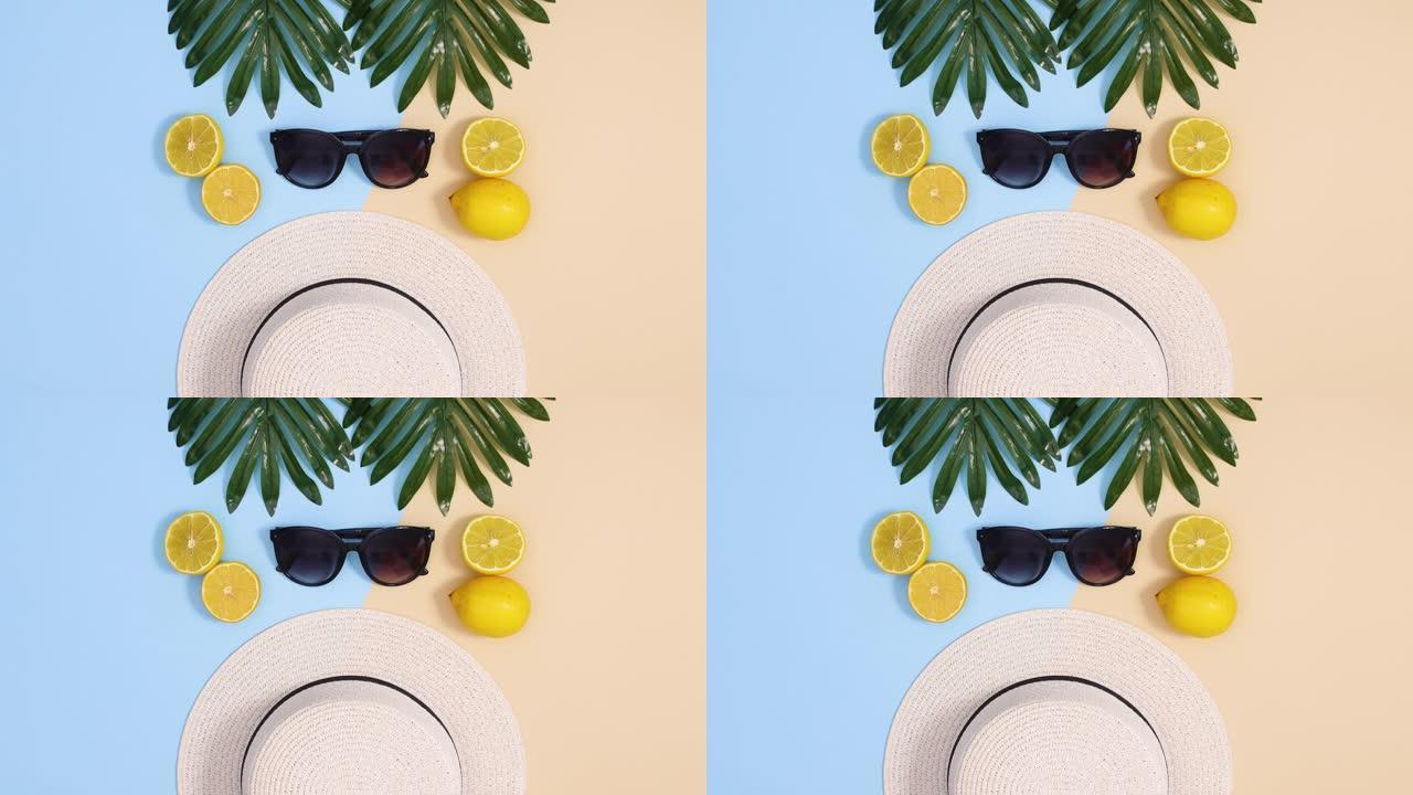 夏季热带停止运动平躺。异国情调的叶子，帽子，太阳镜和柠檬出现在蓝色的沙质背景上