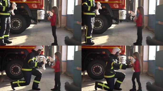消防卫兵在车站给一个小女孩一个玩具