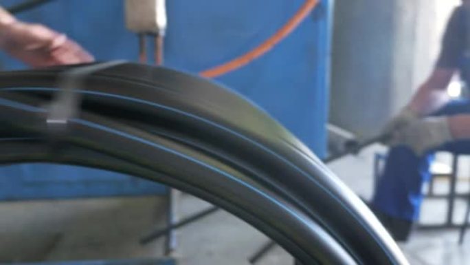 轧辊螺纹盘管。塑料水管制造厂。利用水和气压在机床上制作塑料管的过程。