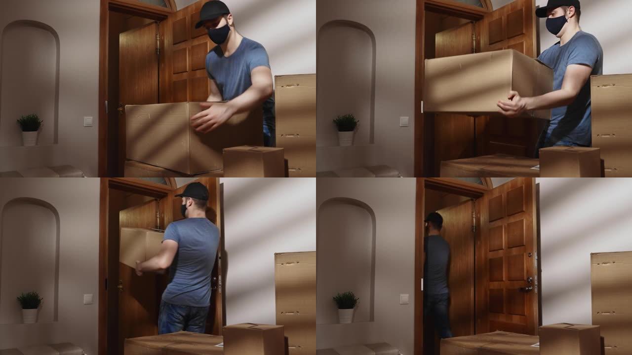 蒙面人从公寓里拿起纸箱。