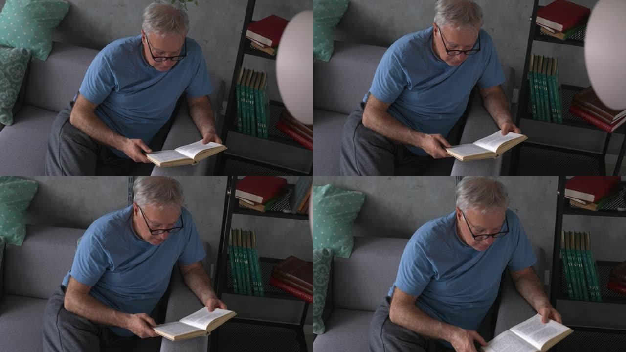 老人坐在沙发上看书，在家放松