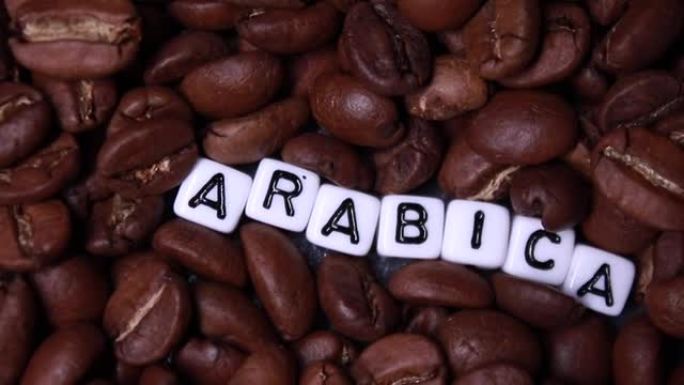 滑过用白色小方块写的阿拉比卡单词的烤咖啡豆。阿拉比卡和罗布斯塔