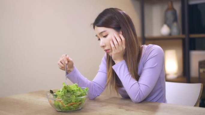 不满意的女人在寻找沙拉，健康的低热量饮食来减肥