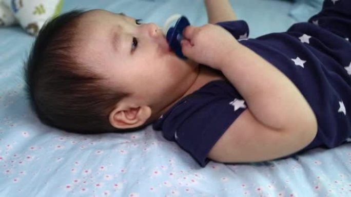 8个月中国男婴吸吮奶嘴准备入睡的当地生活方式