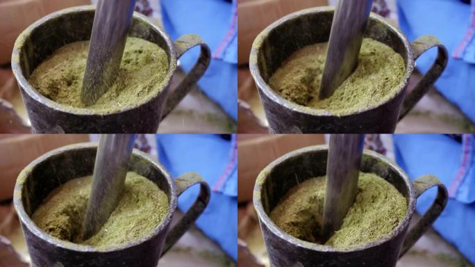 在摩洛哥马拉喀什，用传统的铁砂浆将指甲花叶子磨成粉末。