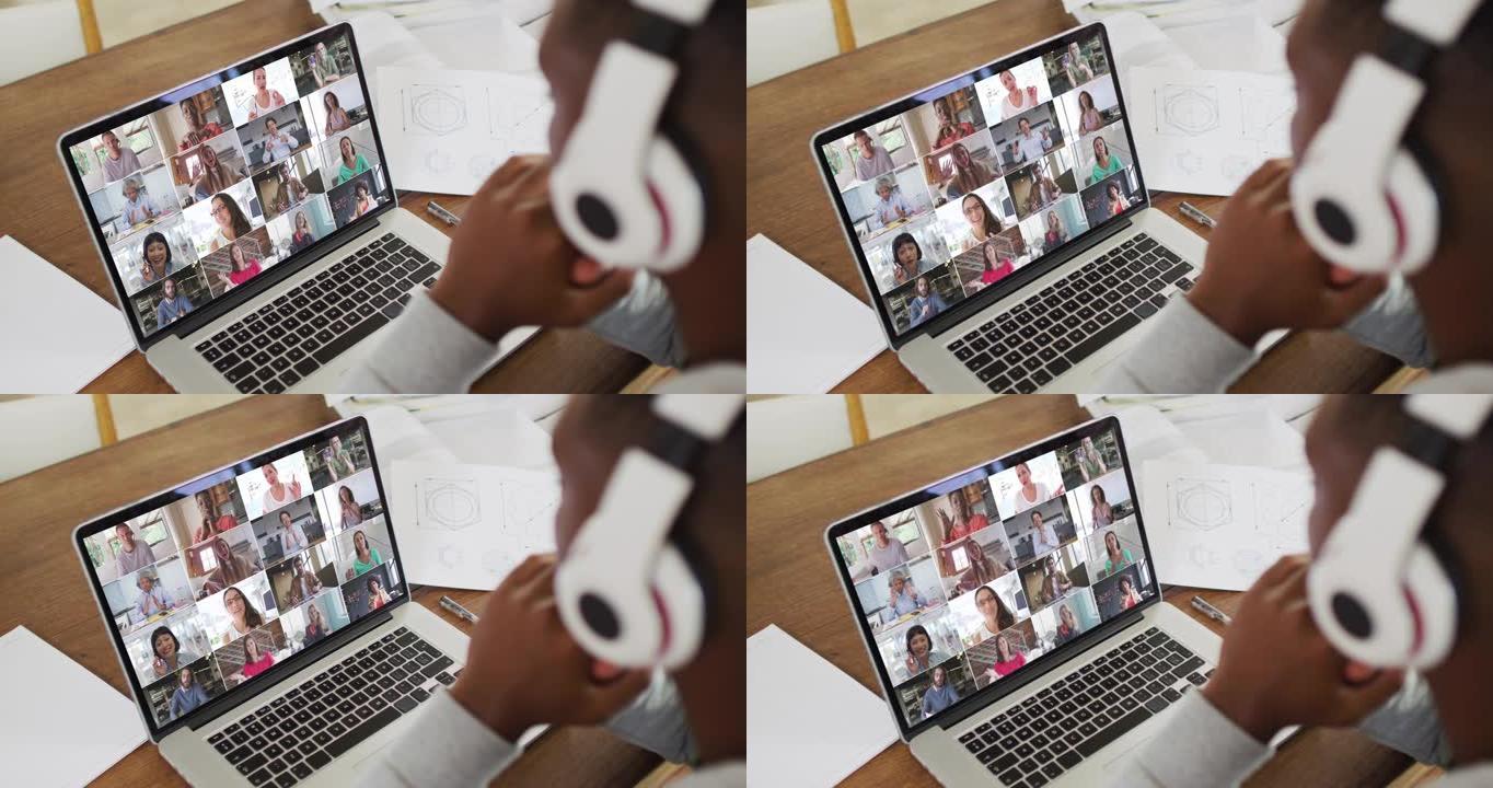 非裔美国男大学生拿着笔记，在家用笔记本电脑开视频会议