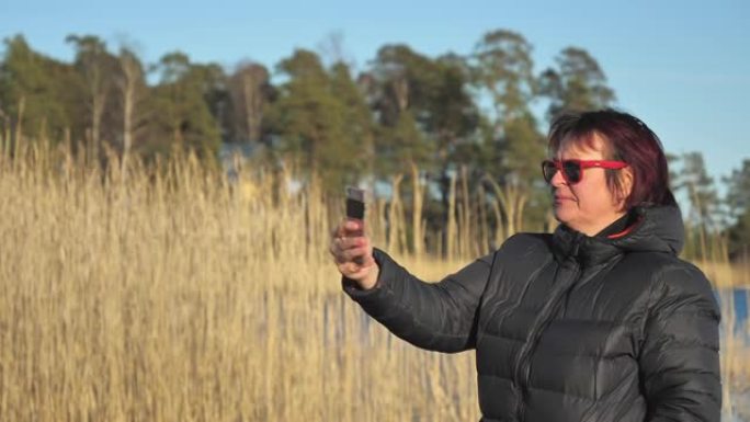 这位女士在芬兰自拍时，背面高高的草的景色