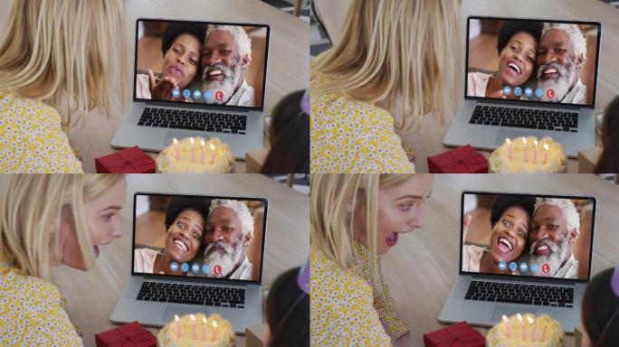 高加索母亲和女儿在家里用笔记本电脑进行视频通话时庆祝生日