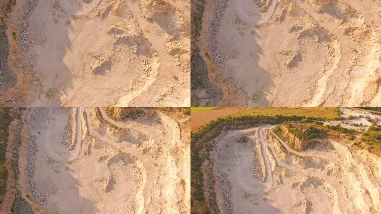 空中俯视图到一个巨大的沙坑底部。一个男人在沙质采石场弹钢琴。超现实主义