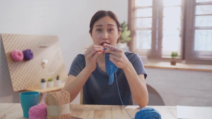 年轻的亚洲女性在客厅为自己的爱好编织钩针，在家创业