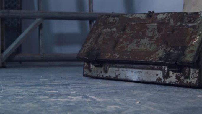 废旧仓库中生锈的旧工具箱和油漆覆盖板的滑动镜头