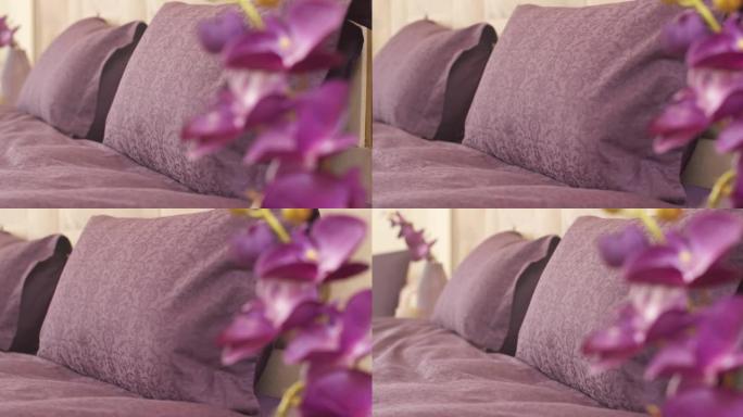 床上有花卉图案和紫色封面的紫色枕头特写