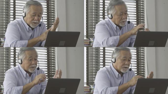 一位老年商人戴着耳机，在检疫期间使用视频会议进行商务会议。