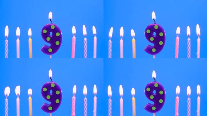 燃烧的生日蜡烛孤立在蓝色背景上，编号9
