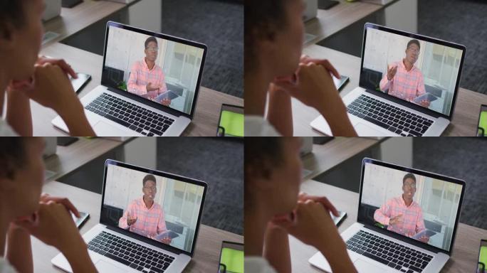 非裔美国妇女的中部与办公室的男同事在笔记本电脑上进行视频通话