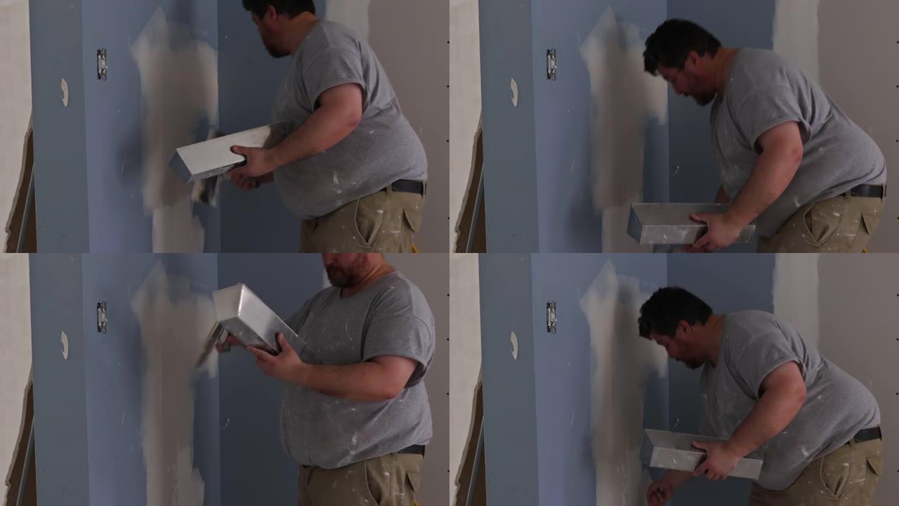 用抹灰工男子粉刷墙和腻子石膏对齐墙的公寓装修工程