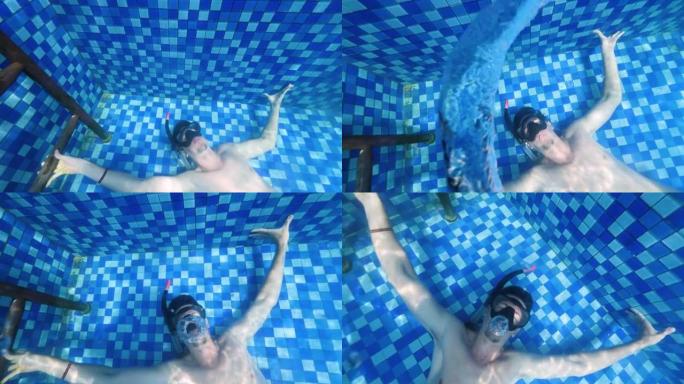 一个在水下的人在游泳池里制造泡泡环。