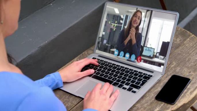 白人妇女的中部与笔记本电脑上的女同事进行视频通话
