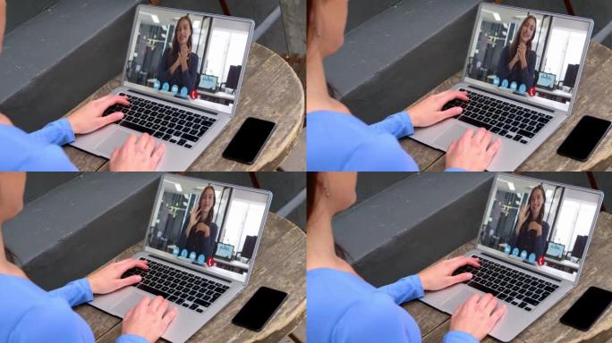 白人妇女的中部与笔记本电脑上的女同事进行视频通话