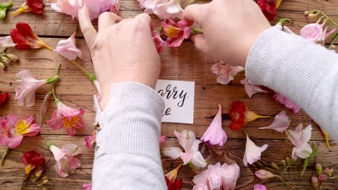 在木桌上的MARRY ME卡片上放一朵花
