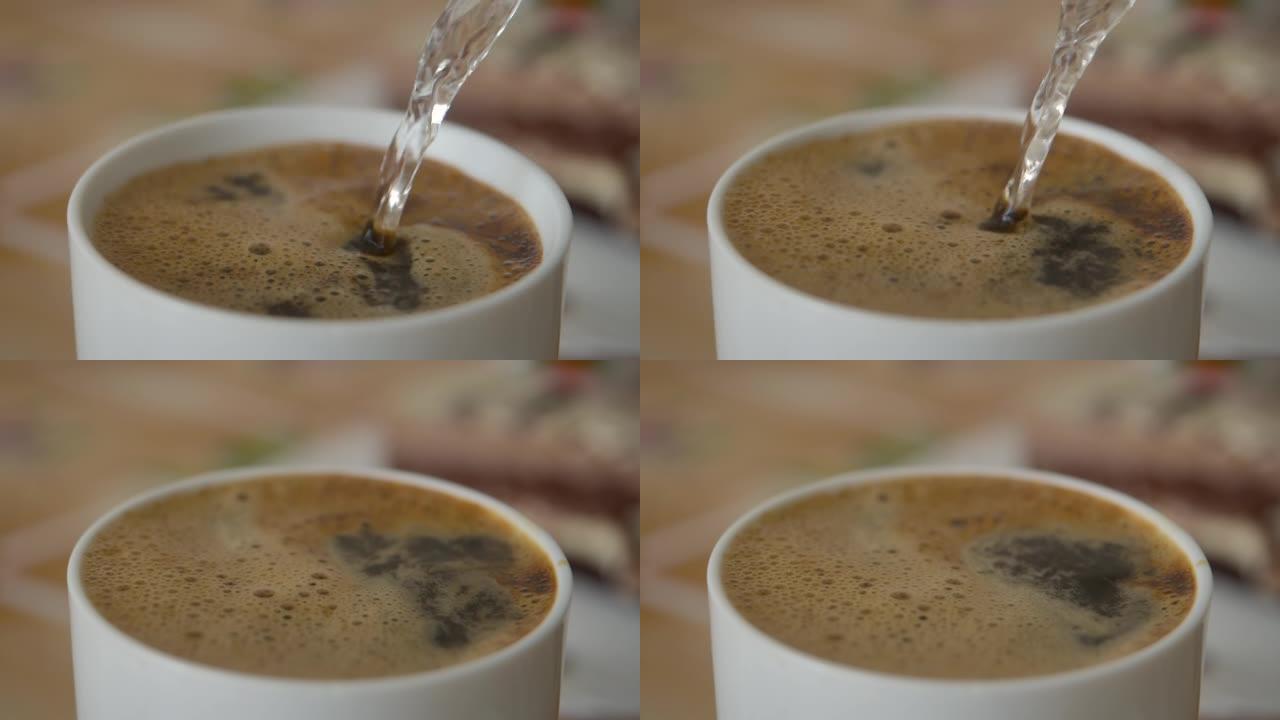 将热水倒入白杯巧克力中。新鲜的早晨倒在咖啡上特写。慢动作。白色杯子里的牛奶巧克力。从水壶里倒热水，做