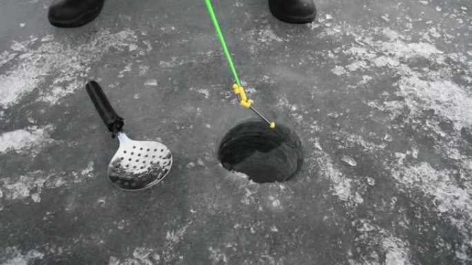 在冰冻的湖上冬季钓鱼