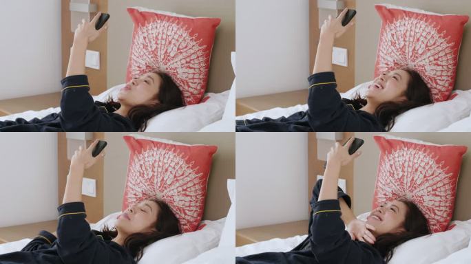 美女开心躺在床上玩手机视频聊天