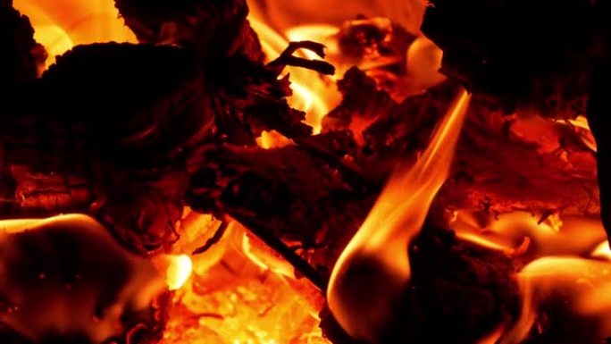 在农村烤箱里烧柴。黑暗中木头炉子的红色橙色火焰。舒适的热壁炉篝火燃烧在晚上。明亮温暖的屏幕保护4K，