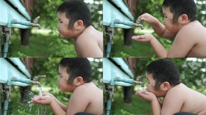 亚洲男孩的慢动作从水龙头喝到户外的淡水，节约用水的概念。